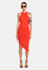 Rotes, ärmelloses Kleid mit asymmetrischem Saum und ger Raffstruktur auf einer Seite. Verfügt über einen metallischen Akzentgurt und eine figurbetonte Passform.
