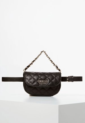 Black quilted leather Guess belt bag with gold chain handle and front logo, displayed on a white surface against white background.