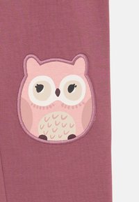 Rosa stoff med et sydd ekorn-patch med store øyne og mønstrete mage. Patchen er kantet med en mørkere rosa kontur.