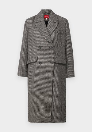 Cappotto doppiopetto in un motivo houndstooth bianco e nero, con colletto a bavero, due tasche frontali e bottoni neri.