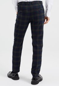 Mörkblå rutig byxor med gröna och röda mönster, med slim fit, två bakfickor och en slät tygtextur.