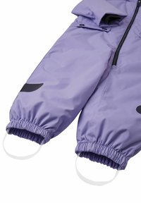 Fioletowy wodoodporny kombinezon narciarski z elastycznymi mankietami, czarnymi akcentami, regulowanymi paskami i zamkiem błyskawicznym z przodu, co ułatwia zakładanie i zdejmowanie.