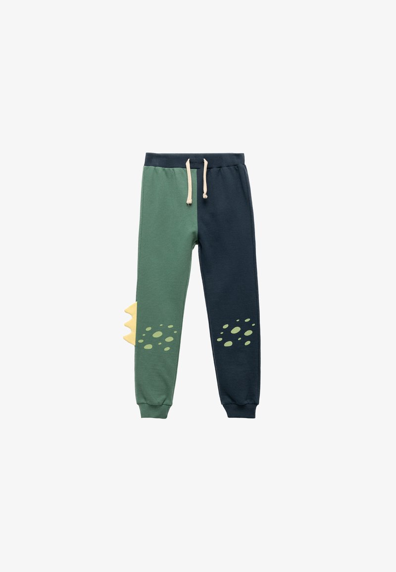 Groene en marineblauwe trainingsbroeken met een touwsluiting in de taille, voorzien van een gele schubbenprint en cirkelvormige patronen op de knieën. Zachte stoftextuur.