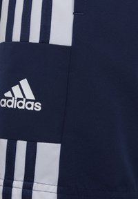 Marineblau und weißer Adidas-Stoff mit drei marineblauen Streifen und weißem Adidas-Logo im marineblauen Bereich.