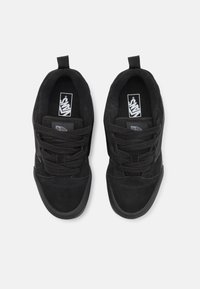 Baskets en suède noir avec finition texturée, dotées de lacets ronds, d'un col rembourré et d'un logo sur le côté. Design simple et discret.