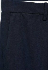 Pantalons en laine bleu marine avec un motif en chevrons, taille plate et une ceinture lisse avec passants. Design texturé et ajusté.