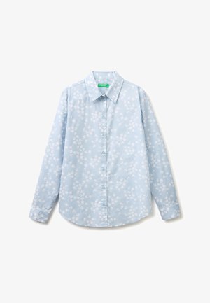 Jasnoniebieska koszula na długi rękaw z guzikami, z białym kwiatowym wzorem i szpiczastym kołnierzem, rozłożona na płasko na białym tle.