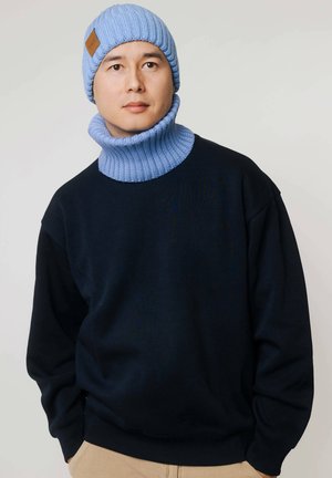 Dziana czapka i komin w jasnoniebieskim kolorze z prążkowanym wzorem. Połączone z ciemnogranatową bluzą z okrągłym dekoltem. Prosty design.