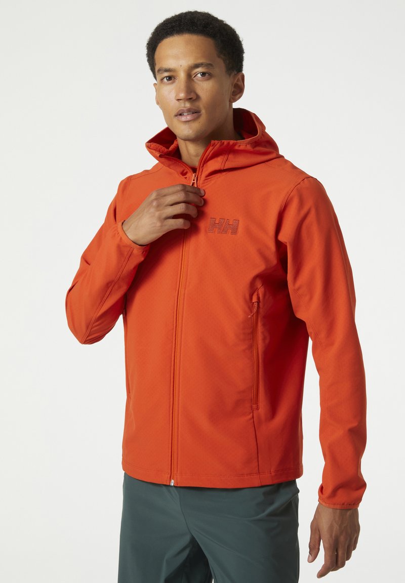 Chaqueta naranja con cremallera y capucha, que presenta un tejido texturizado, dos bolsillos laterales y un logo sutil en el pecho.