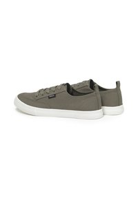 Green canvas sneakers with white rubber soles, featuring round laces and a small logo tag on the side. Smooth texture with a low-profile design.