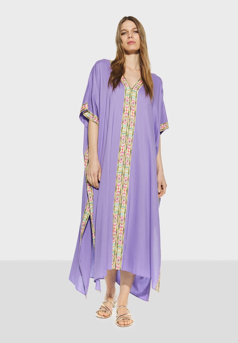 Lila kaftan med blommönstrad kant och V-ringning, med korta ärmar och en flödande design för enkel rörelse.