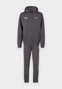 Sweatshirt cinzento com bolso frontal e capuz ajustável por cordão, combinado com calças slim-fit a condizer, apresentando um cós elástico e punhos.