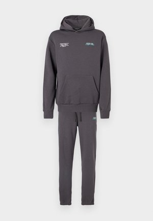 Sweatshirt cinzento com bolso frontal e capuz ajustável por cordão, combinado com calças slim-fit a condizer, apresentando um cós elástico e punhos.