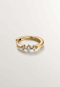 Anillo de oro con tres diamantes redondos, la piedra central más grande flanqueada por dos más pequeñas, banda suave con un acabado pulido.