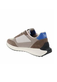 Sneaker grigia e marrone con una tomaia perforata e dettagli in suede, un tab sul tallone blu e una suola intermedia bianca con suola esterna nera texturizzata.