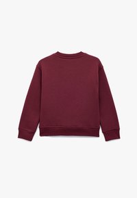Bluza w kolorze bordo z okrągłym dekoltem, prążkowanymi mankietami i dołem. Gładka tekstura, minimalistyczny design i luźny krój.