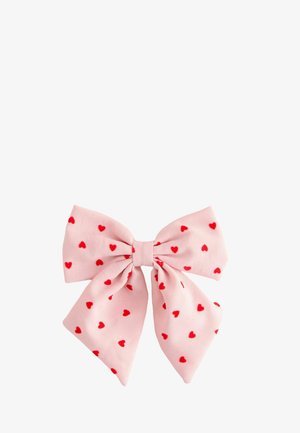 Pink fabric bow with red heart patterns evenly distributed across the entire bow on a white background.