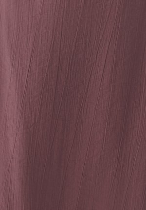 Gekreukt stof in een rijke bordeauxkleur, met een getextureerd oppervlak en zichtbare plooien. Het materiaal lijkt lichtgewicht en valt soepel.