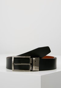 Ceinture en cuir noir avec une boucle rectangulaire en argent brillant et une texture lisse. L'intérieur présente une couleur brune contrastante.