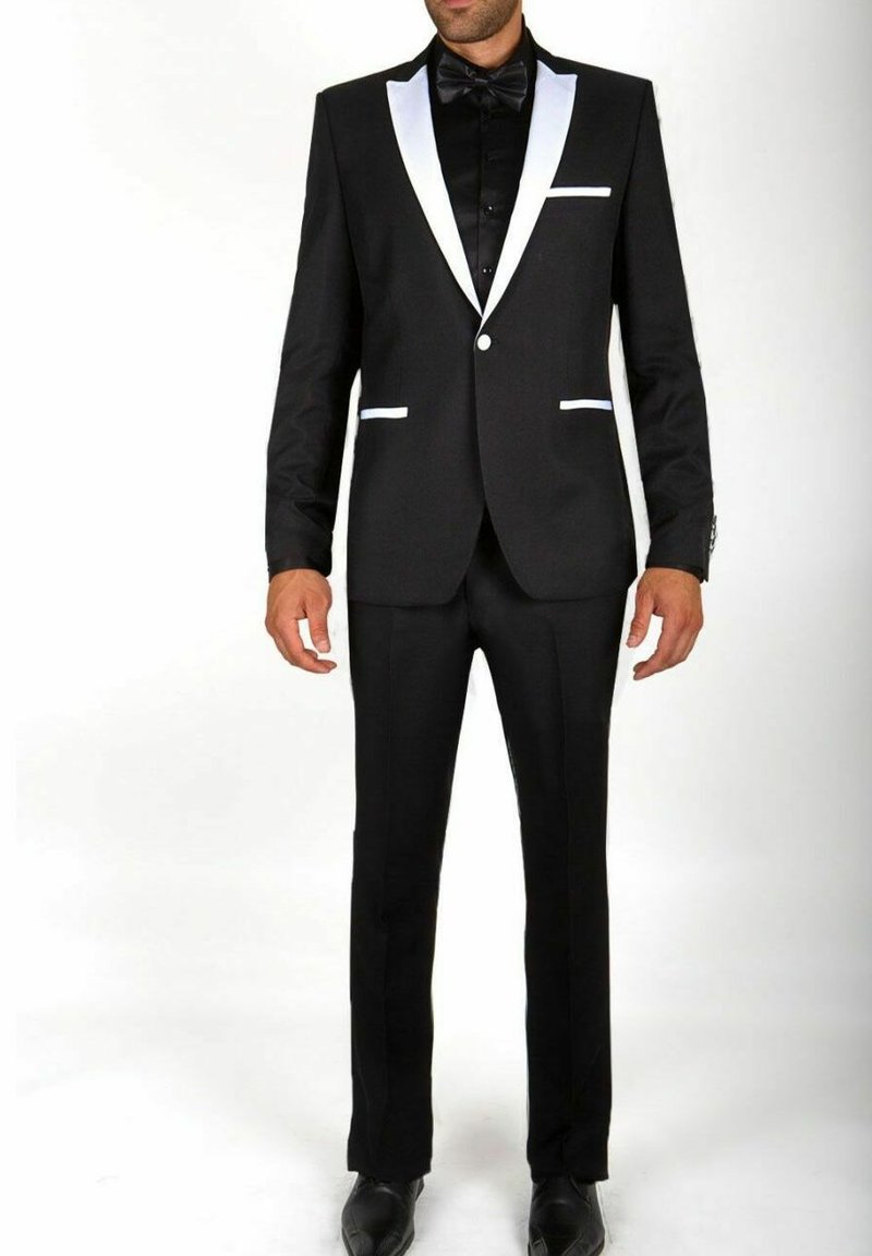 Smokings noirs avec des revers en satin blanc et des accents de poche. Design ajusté, associé à un nœud papillon noir et des chaussures noires classiques.