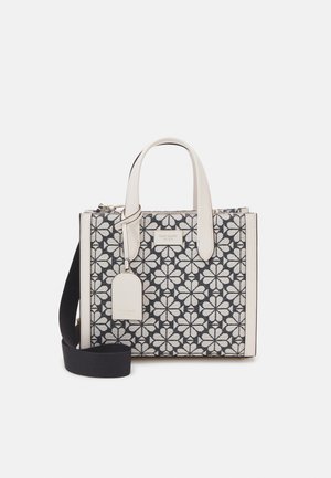 Black and white floral patterned handbag with cream-colored leather accents, dual top handles, and detachable black shoulder strap.