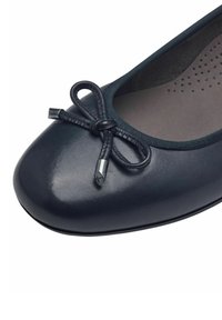 Ballet flat in pelle nera con punta arrotondata, caratterizzata da un fiocco in satin e dettagli metallici, soletta texturizzata e bordino elasticizzato.