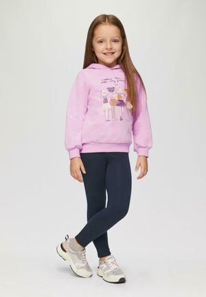 Helle lila Kapuzenjacke mit grafischer Illustration und Text, kombiniert mit marineblauen Leggings und grauen Sportschuhen. Glattes Material und entspannter Schnitt.