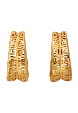 Een paar gouden oorringen in hoefijzervorm met ingewikkelde geometrische uitsnijdingen en getextureerde randen, afgebeeld tegen een witte achtergrond.