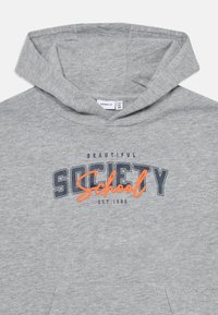 Un sweat à capuche gris en tissu doux avec une poche avant et un cordon de serrage. Un graphique de texte en bleu marine et orange indique "École de la Belle Société."