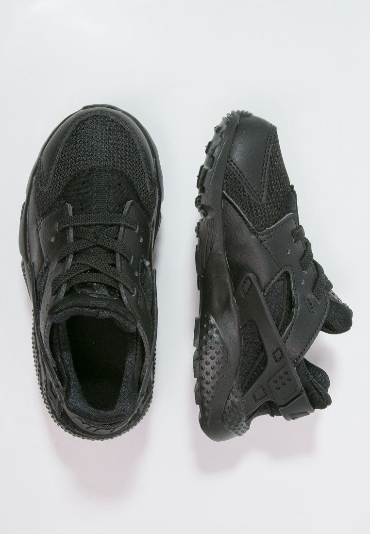 Zapatillas deportivas negras que presentan una combinación de materiales de malla y sintéticos, con una suela texturizada, diseño de cordones y acentos de soporte.