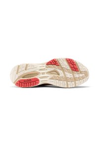 Shoe sole in beige with red accents; features textured rubber tread for grip; includes "Reebok" logo embossed in red.