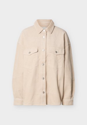 Chemise beige en velours côtelé avec boutons, deux poches poitrine à rabat et manches longues, présentée sur un fond blanc.