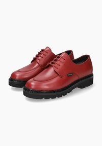 Chaussures en cuir rouge avec un bout arrondi, présentant une finition lisse, un design à lacets et une semelle en caoutchouc noir épaisse.