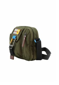 Borsa a tracolla in tessuto verde con una tasca frontale con zip, tracolla regolabile e dettagli in metallo blu. Presenta un'etichetta con il logo Discovery.