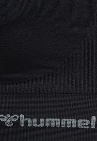 Zwarte stof met een ribbelstructuur, met een prominent lichtgrijs "hummel" logo en een gladde afwerking bij de randen.