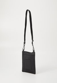 Čierna nylonová crossbody taška s textúrovaným povrchom, nastaviteľným popruhom a prednou vreckom. Elegantný, obdĺžnikový dizajn so striebornými doplnkami.