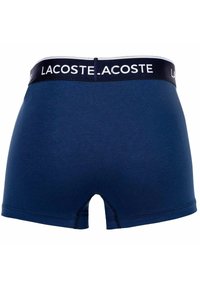 Navy bomullsboxershorts med ett vitt och navy LACOSTE-logoband, som har en mjuk yta och en medellång passform med rund benöppning.