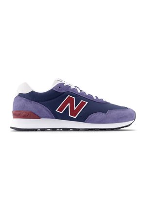 Scarpa da ginnastica New Balance blu navy e viola con lacci bianchi e suola bianca, logo rosso sul lato e accento rosso sul tallone, mostrata di profilo.