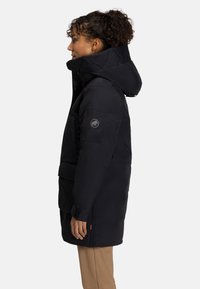 Zwarte geïsoleerde parka met een hoge kraag en een verstelbare capuchon, voorzien van een borstzak, zijzakken en een logo-opervers op de arm.