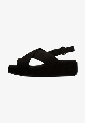 Sandales compensées en daim noir avec design à brides croisées, bout ouvert, bride de cheville réglable avec boucle ronde, et semelle plateforme épaisse.