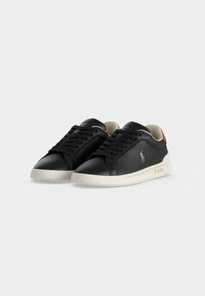 Ζευγάρι μαύρα δερμάτινα sneakers χαμηλού τύπου με λευκές σόλες, μαύρα κορδόνια και ένα μικρό πολύχρωμο λογότυπο Polo στο πλάι.