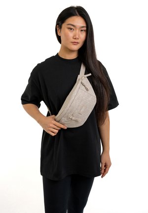 Marsupio fanny pack beige con motivo geometrico, realizzato in materiale leggero, dotato di chiusura con zip e tracolla regolabile, indossato a tracolla.