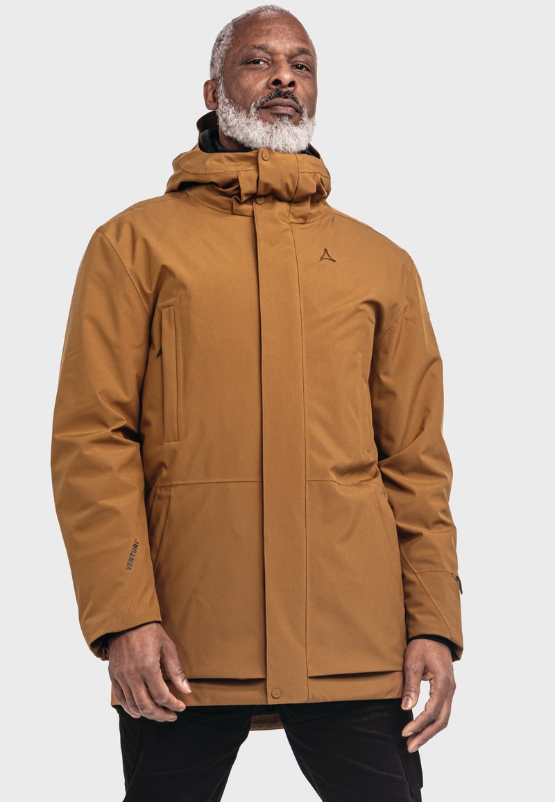Braune, wasserdichte Jacke mit hohem Kragen und verstellbarem Kapuze. Sie hat eine glatte Textur, Fronttaschen und ein Logodetail auf der Brust.