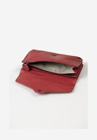 Red leather clutch with a zippered compartment and snap closure, featuring a striped fabric interior and smooth, matte texture.