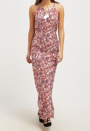 Robe maxi avec un motif cachemire dans des tons rouges et roses, dotée d'un décolleté halter et de détails en franges blanches, cintrée à la taille.