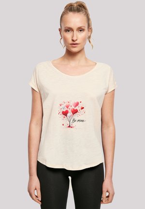Beige short-sleeve t-shirt featuring a graphic of red and pink hearts with the text "Be mine" beneath, made of soft fabric with a relaxed fit.