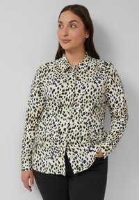 Leopardprint blouse in crèmekleurig en zwart, met een knoopsluiting aan de voorkant, kraag en lange mouwen, gemaakt van gladde, gestructureerde stof.
