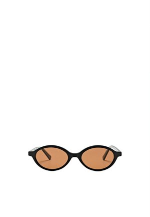 Lunettes de soleil ovales noires avec des verres fins teintés marron et des branches fines noires sur fond blanc.