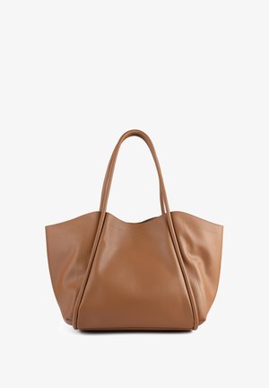 Tan leather tote bag with a soft, smooth texture, featuring two long handles and a structured, angular design. Subtle stitching details.