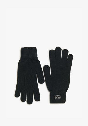 Guantes de lana negros con puños acanalados, con una etiqueta que dice "Ropa de Trabajo Tradicional Superdry". Textura suave y diseño ajustado.